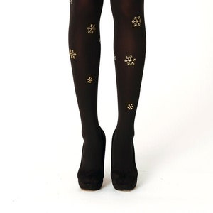 May include: Black tights with a snowflake pattern in gold.