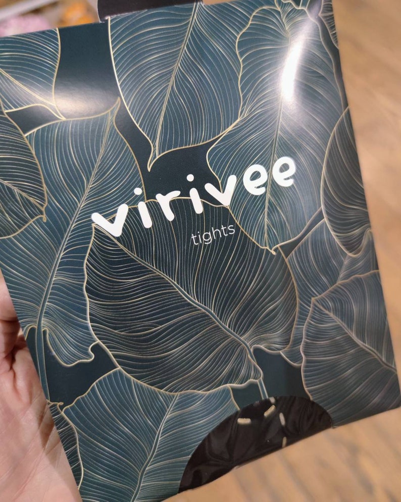 May include: A dark green and gold packaging with a leafy pattern for Virivee tights.