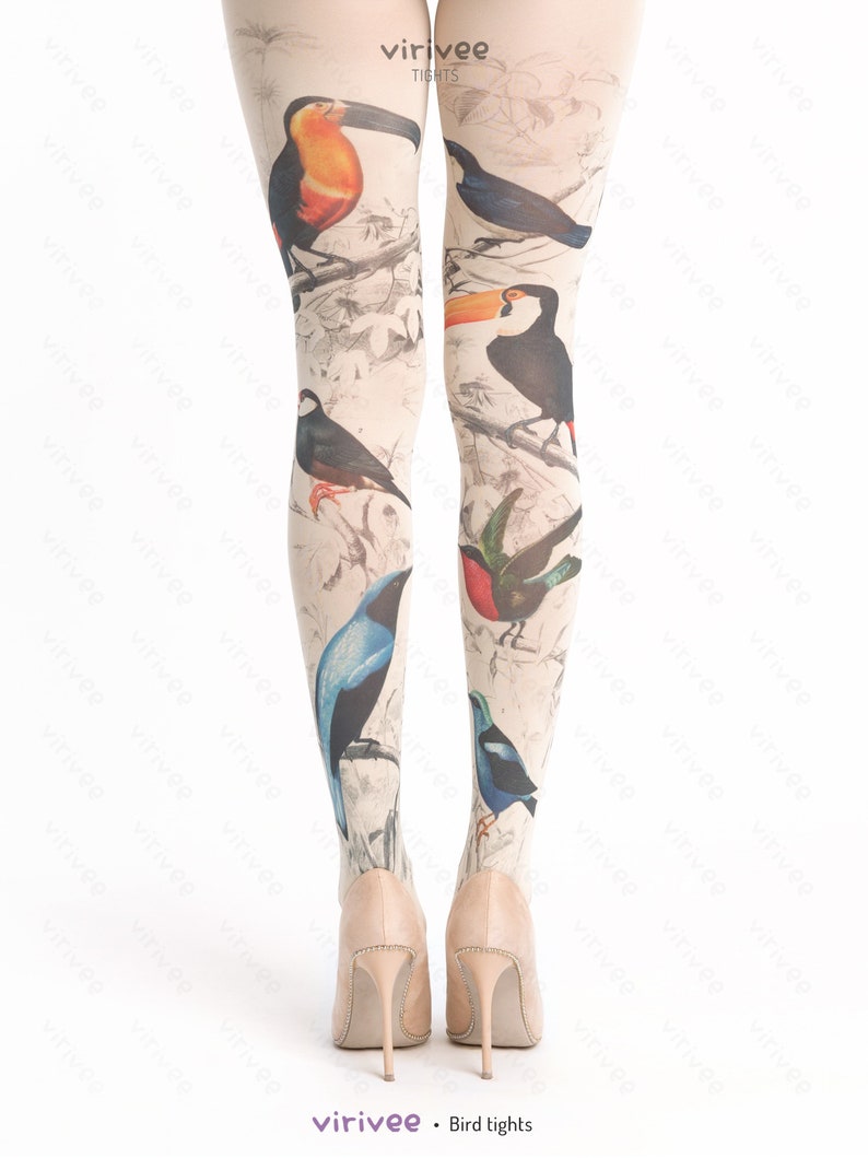 May include: A pair of beige tights with a bird print design. The tights feature toucans, bluebirds, and other birds on a white background. The text "virivee TIGHTS" is printed on the tights.