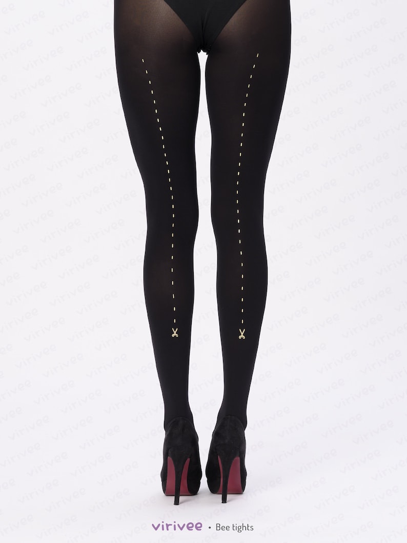 May include: Opaque black tights featuring a vertical line of small, light-colored dashed marks running down the back of each leg. At the bottom of each dashed line, there is a small, light-colored icon of a pair of open scissors.