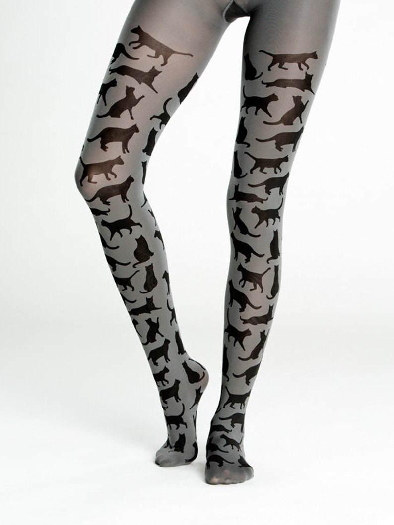 May include: Gray tights with a black cat silhouette pattern. The cat silhouettes are repeated throughout the tights.