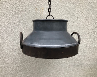 May include: A black metal hanging light fixture with a round, slightly domed shade and two handles on the sides. The fixture is suspended from a chain.
