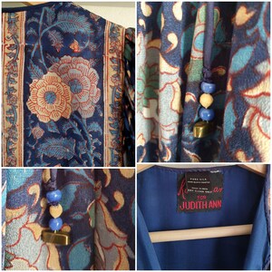 May include: A vintage blue silk dress with a floral pattern in shades of red, beige, and teal. The dress features a drawstring with blue beads and a gold-coloured charm. The label reads "Judith Ann."