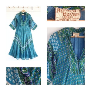Puede incluir: Un vestido maxi de estampado azul y verde con escote en V y mangas 3/4. El vestido tiene una etiqueta que dice "Ayesha Davar London 100% Algodón Lavar a mano por separado Hecho en India".
