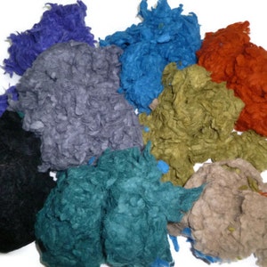 Può includere: Assortimento di filati colorati, soffici e testurizzati in tonalità di blu, verde, grigio, marrone, nero e arancio.