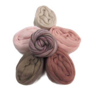 May include: Five balls of wool yarn in various shades of pink, brown, and beige. The yarn is arranged in a star shape.