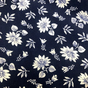 Puede incluir: Una tela azul marino con un patr&oacute;n floral blanco. El patr&oacute;n presenta peque&ntilde;as flores blancas, hojas y bayas.