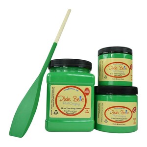 May include: Three jars of Dixie Belle Paint Company Tree Frog Green chalk mineral paint in 8, 16, and 32 ounce sizes. The paint is a bright green color and the jars have black lids. The jars are labeled with the Dixie Belle Paint Company logo and the paint color and size. The paint is made in the USA and is zero VOC.