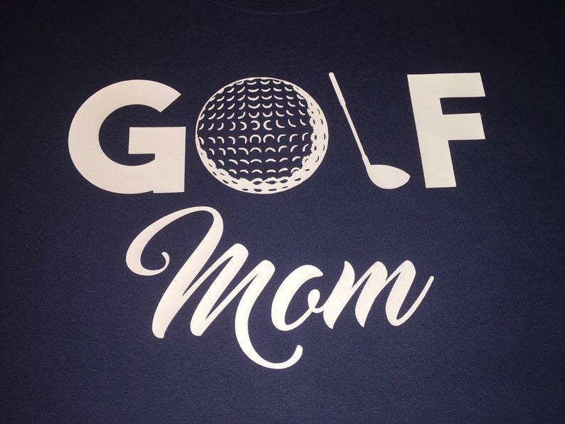 May include: A navy blue t-shirt with white text that reads "GOLF Mom" and a white golf ball and club graphic.