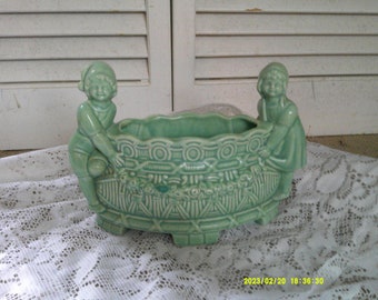 Lovely Soft Green Planter, Little Holland Boy and Girl beside a Wishing Well, 9 inches across and 4 1/4 inches wide. Small chip on front.