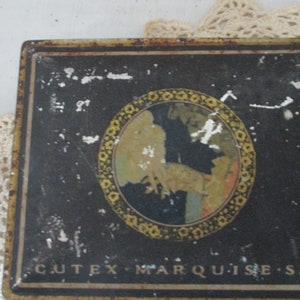 May include: A vintage Cutex Marquise Set tin box. The black rectangular box has a gold border and a central circular design. The design features a woman and a floral border. The text "CUTEX MARQUISE SET" is printed on the bottom of the box.