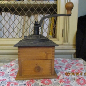 What a cute Coffee Grinder, Cast Iron and Wood, Decorative Black Iron on the top, Dove tailed joints, and Little Drawer.