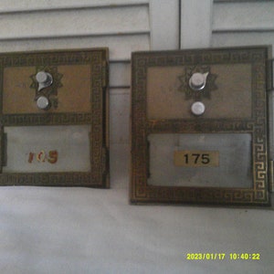 Peut inclure: Deux boîtes aux lettres en laiton vintage avec des fenêtres en verre et des numéros. La boîte aux lettres de gauche porte le numéro 105 et celle de droite le numéro 175.