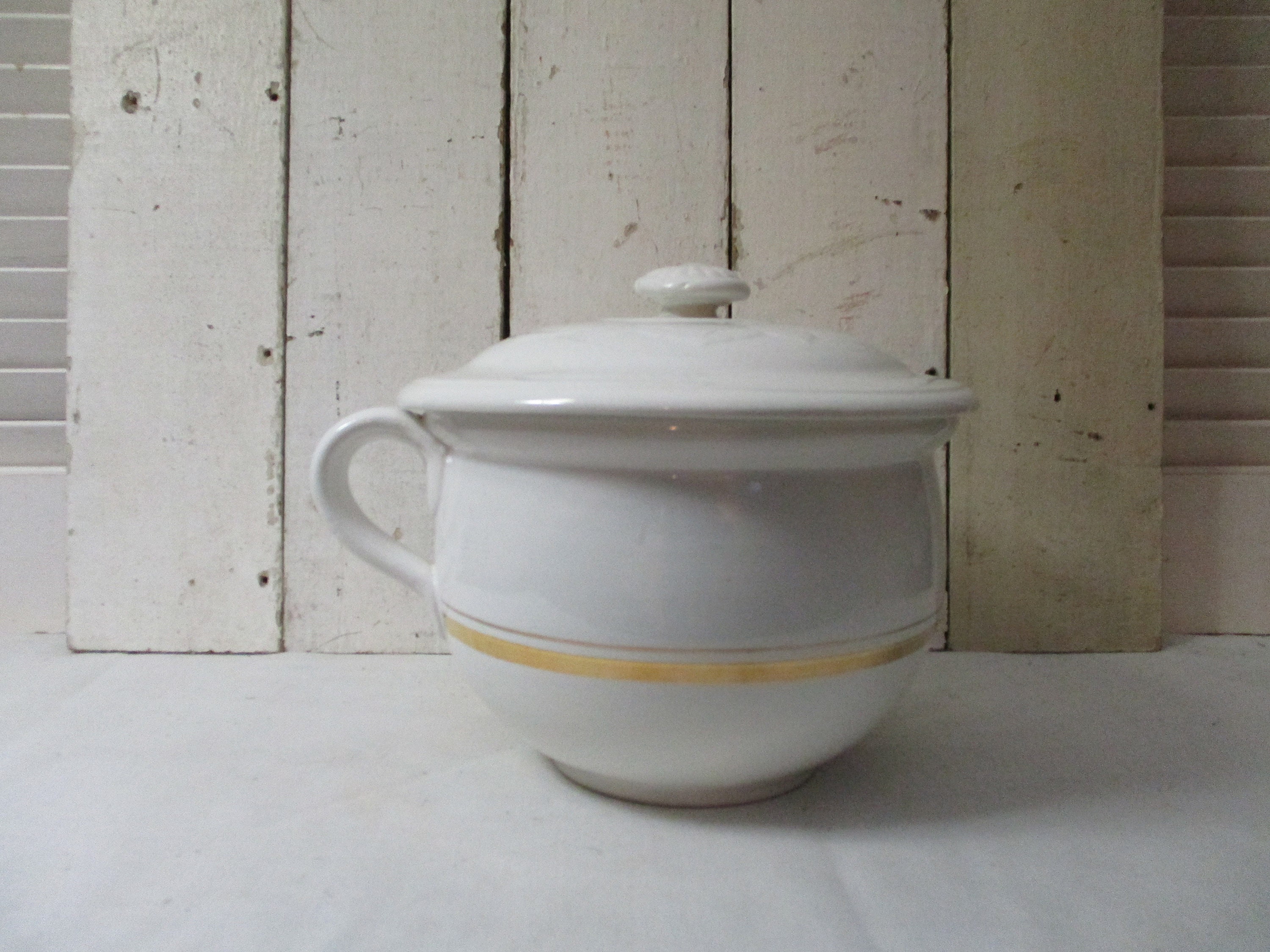 White Ironstone Chamber Pot trimmed in Gold, Measures 8 1/2" across and stands 5 3/4" high.