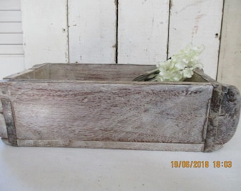 May include: A weathered wooden box with a whitewashed finish. The box is empty and has a rustic appearance.