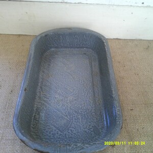 May include: A gray enamel baking dish with a speckled finish. The dish is rectangular and has a slightly rounded edge.