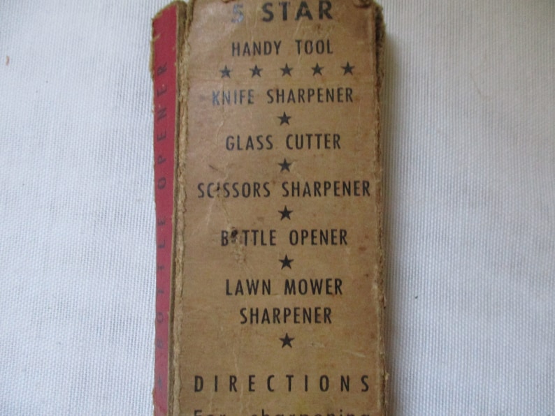 May include: A brown cardboard box with the text "5 STAR HANDY TOOL" and a list of tools it contains: "KNIFE SHARPENER", "GLASS CUTTER", "SCISSORS SHARPENER", "BOTTLE OPENER", and "LAWN MOWER SHARPENER".