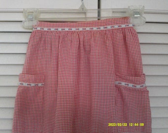 Red Gingham Check Half Apron, 2 Pockets, Small Flowered Trim. Vintage Apron, small hold in the front. Waist line measures 70 inches.