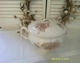 Hermosa olla de cámara de transferencia marrón con tapa a juego, olla y tapa de piedra de hierro, asa elegante en el costado y en la tapa.