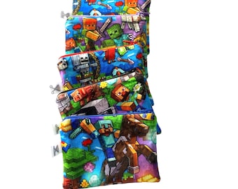 May include: A stack of six colorful zippered pouches with a Minecraft character print. The pouches are made of fabric and have a blue background with various Minecraft characters, including Steve, a creeper, and a pig.