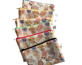 Könnte beinhalten: Eine Reihe von Reißverschlusstaschen mit einem sich wiederholenden Muster von Cartoon-Hasen in verschiedenen Outfits. Die Taschen haben Reißverschlüsse in verschiedenen Farben, darunter Blau, Gelb, Rosa, Grün, Rot und Schwarz. Der Hintergrund ist weiß.
