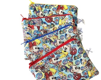Könnte beinhalten: Vier farbenfrohe Reißverschlusstaschen mit blauem Hintergrund und einem sich wiederholenden Muster von Mickey Mouse, Minnie Mouse, Donald Duck und Alice im Wunderland. Die Taschen sind übereinander gestapelt.