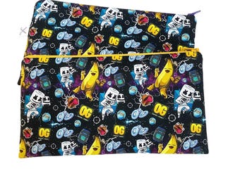 Könnte beinhalten: Schwarze Reißverschlusstasche mit einem sich wiederholenden Muster aus Zeichentrickfiguren, Bananen und dem Wort "OG" in Gelb und Weiß. Der Hintergrund ist ein Galaxiemuster. Die Tasche hat ein gelbes Gummiband.