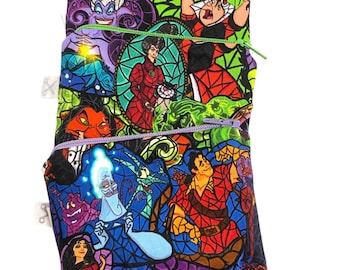May include: A colorful zippered pouch featuring stained-glass style illustrations of animated characters. The pouch has a black background with images of villains and heroes in vibrant colors. The pouch has three zippered compartments with purple, green, and red zippers.