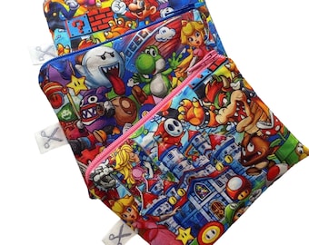 May include: Four colorful zippered pouches with a variety of Super Mario characters printed on them. The pouches are stacked on top of each other.