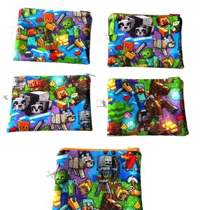 May include: Set of four small zippered pouches with a Minecraft theme. The pouches are made of a soft, blue fabric with a variety of Minecraft characters and items printed on them. The pouches are perfect for storing small items like coins, jewelry, or makeup.