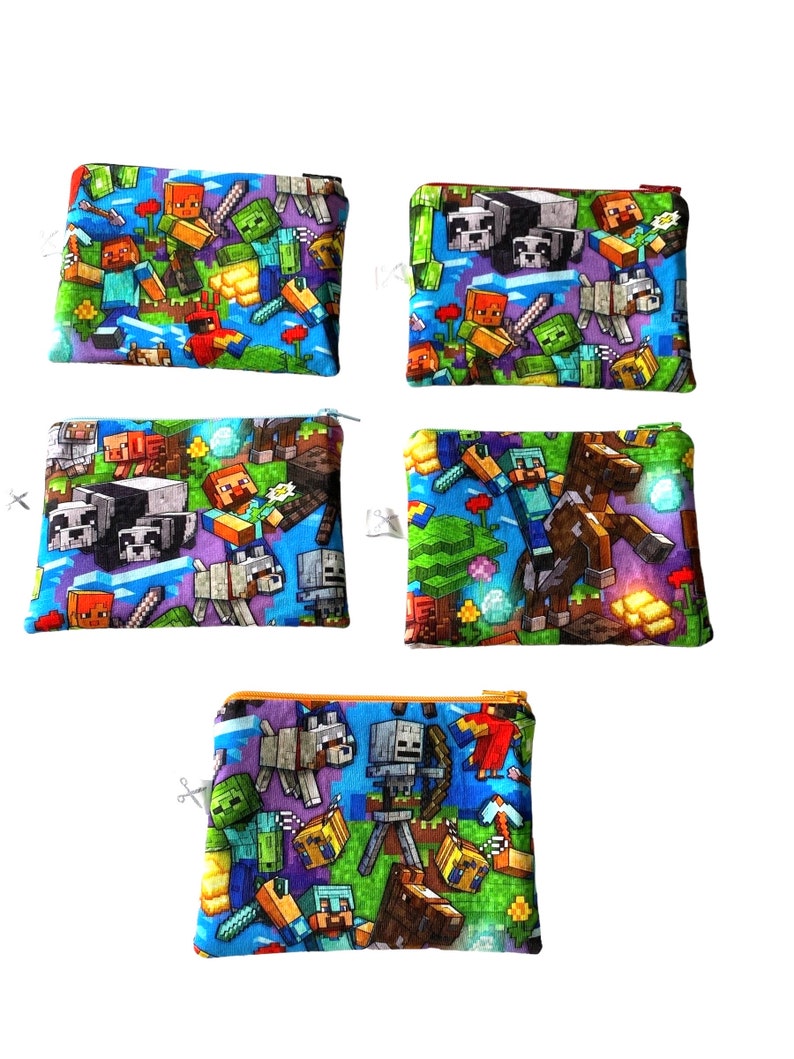 May include: Set of four small zippered pouches with a Minecraft theme. The pouches are made of a soft, blue fabric with a variety of Minecraft characters and items printed on them. The pouches are perfect for storing small items like coins, jewelry, or makeup.