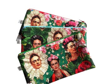 Könnte beinhalten: Drei übereinander gestapelte Reißverschlusstaschen, jede mit einem Frida Kahlo-Porträt auf floralem Hintergrund. Die Taschen haben grüne und rosa Blumenmuster mit grünen und blauen Reißverschlüssen.