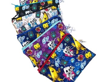 Könnte beinhalten: Eine Reihe von Reißverschlusstaschen mit bunten Mustern. Jede Tasche zeigt ein einzigartiges Design mit Cartoon-Figuren, Bananen und dem Text "OG". Die Taschen haben unterschiedlich farbige Reißverschlüsse und sind aus Stoff.