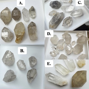 Op de afbeelding: Assortiment van ruwe kwartskristallen in diverse vormen en maten. De kristallen variëren in kleur van helder tot rookgrijs en bruin. Sommige zijn gegroepeerd, andere worden afzonderlijk gepresenteerd. De afbeelding is verdeeld in secties met de labels A t/m E.
