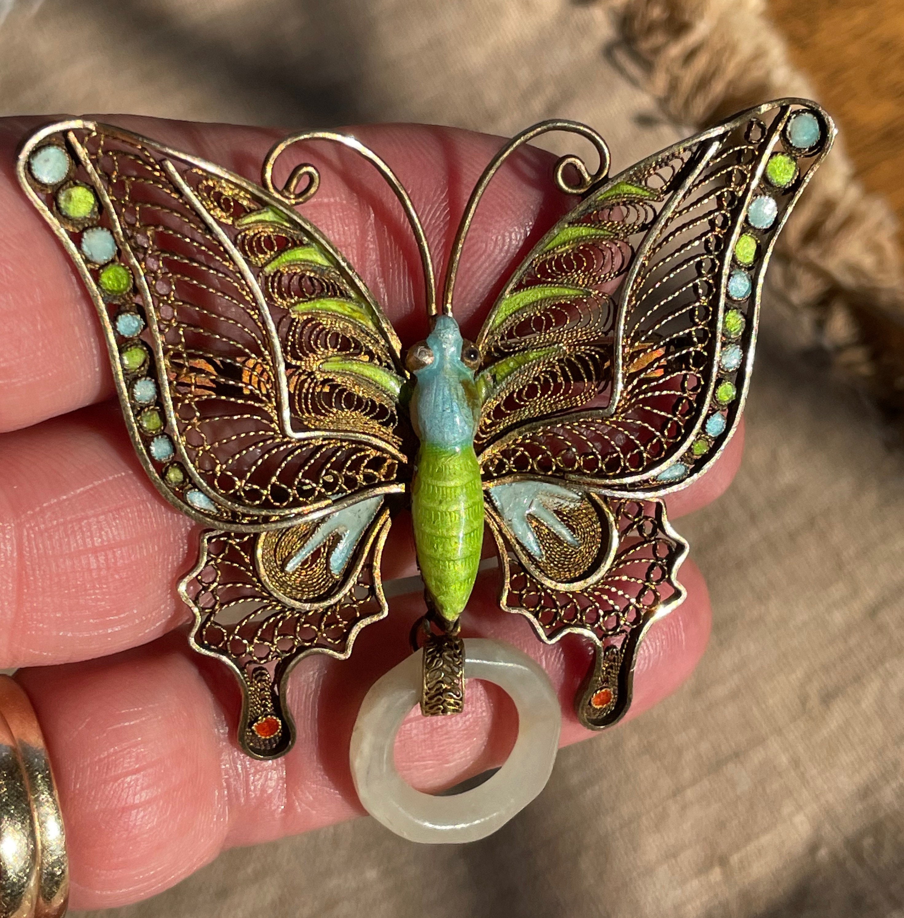 Lot - 14K gold enameled butterfly pin mounted with diamonds and rubies.  Colorful blue and lilac enamel wings. Marked 585 and H script makers mark.  2in wide. Areas where clear coat on