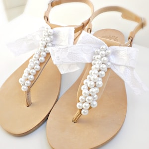 Brautsandalen- Griechische Ledersandalen-Hochzeitssandalen verziert mit weißen Perlen und Satinspitzenschleife -Weiße Frauen Flache- Brautjungfernsandalen