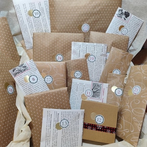 Op de afbeelding: Een verzameling in bruin papier verpakte pakketjes van verschillende groottes, elk met witte stippen of krullende lijnpatronen. Elk pakketje is voorzien van een ronde sticker met een nummer en Griekse tekst.