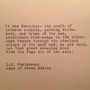 May include: A vintage typewriter quote from the book Anne of Green Gables by L.M. Montgomery. The quote reads: "It was November - the month of crimson sunsets, parting birds, deep, sad hymns of the sea, passionate wind-songs in the pines. Anne roamed through the pineland alleys in the park and, as she said, let that great sweeping wind blow the fogs out of her soul."