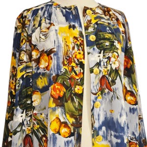 May include: A colorful, open-front jacket with a vibrant floral and fruit print. The jacket features a mix of blue, yellow, and orange hues, with gold-colored buttons. The design includes a botanical theme, with images of oranges and flowers.