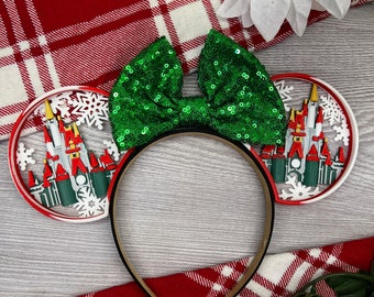 May include: Green sequin bow headband with white and red ears featuring a silhouette of Cinderella's castle with snowflakes.