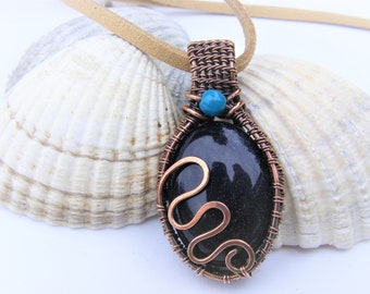 Wire wrapped black sparkly goldstone with chrysocolla accent bead in pure oxidised copper