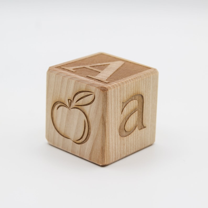 May include: A wooden block with the letter "A" and an apple image engraved on it.