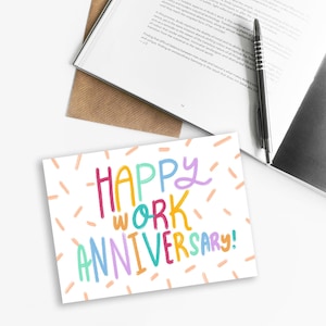 Może przedstawiać: Biała kartka z kolorowym napisem „Happy Work Anniversary!”. Kartka ma wzór konfetti w postaci pomarańczowych i białych linii.