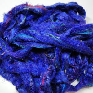 May include: A pile of blue, teal, and purple fiber. The fiber is soft and fluffy, and it is perfect for spinning or felting.