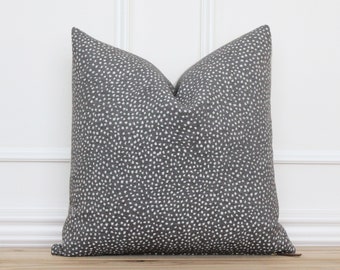 May include: A grey throw pillow with a white polka dot pattern.