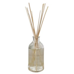 May include: A clear glass reed diffuser bottle with a ribbed design, filled with liquid and topped with several light brown reeds. The bottle has a rounded shape and a narrow neck, suitable for home fragrance.