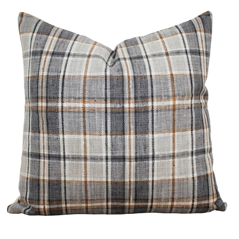 May include: A grey, brown and white plaid throw pillow with a square shape.