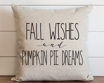 Könnte beinhalten: Ein beiger Dekokissen mit schwarzem Text, der "Fall Wishes and Pumpkin Pie Dreams" lautet.