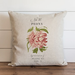 May include: A beige linen cushion featuring a pink peony flower illustration. The cushion has the text "No. 16 PEONY {paeonia} PLATE VI VOL. 5" printed on it.