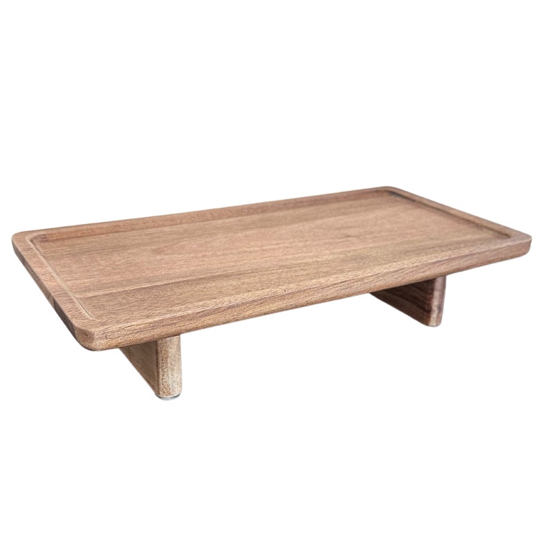 May include: A wooden rectangular tray with two small legs on each side. The tray is made of light brown wood and has a smooth surface.